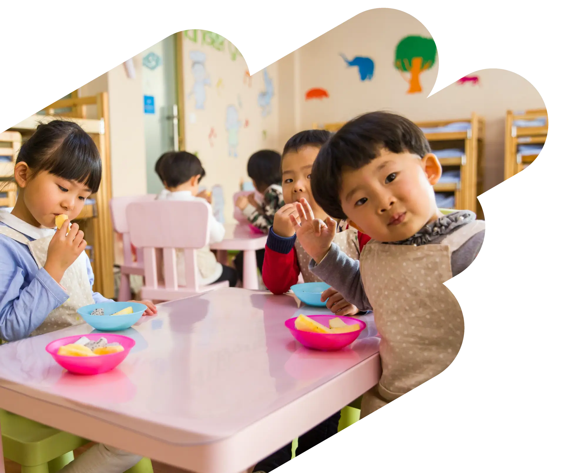 A group of children sitting at a table eating.