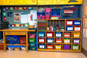 A classroom with lots of colorful bins and shelves.