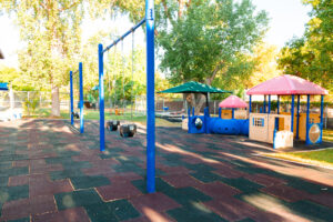 A playground with swings and slides in the middle of it.