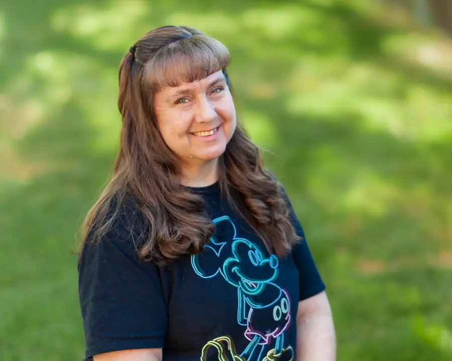 A woman with long hair and a mickey mouse shirt.